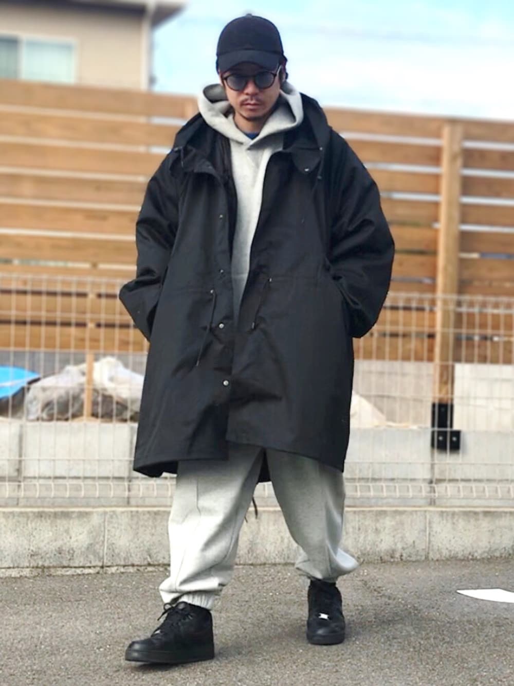 ブラック系のスニーカー、ブラック系のモッズコート、グレー系のスウェットパンツを着用したメンズの冬コーディネートの2枚目の写真