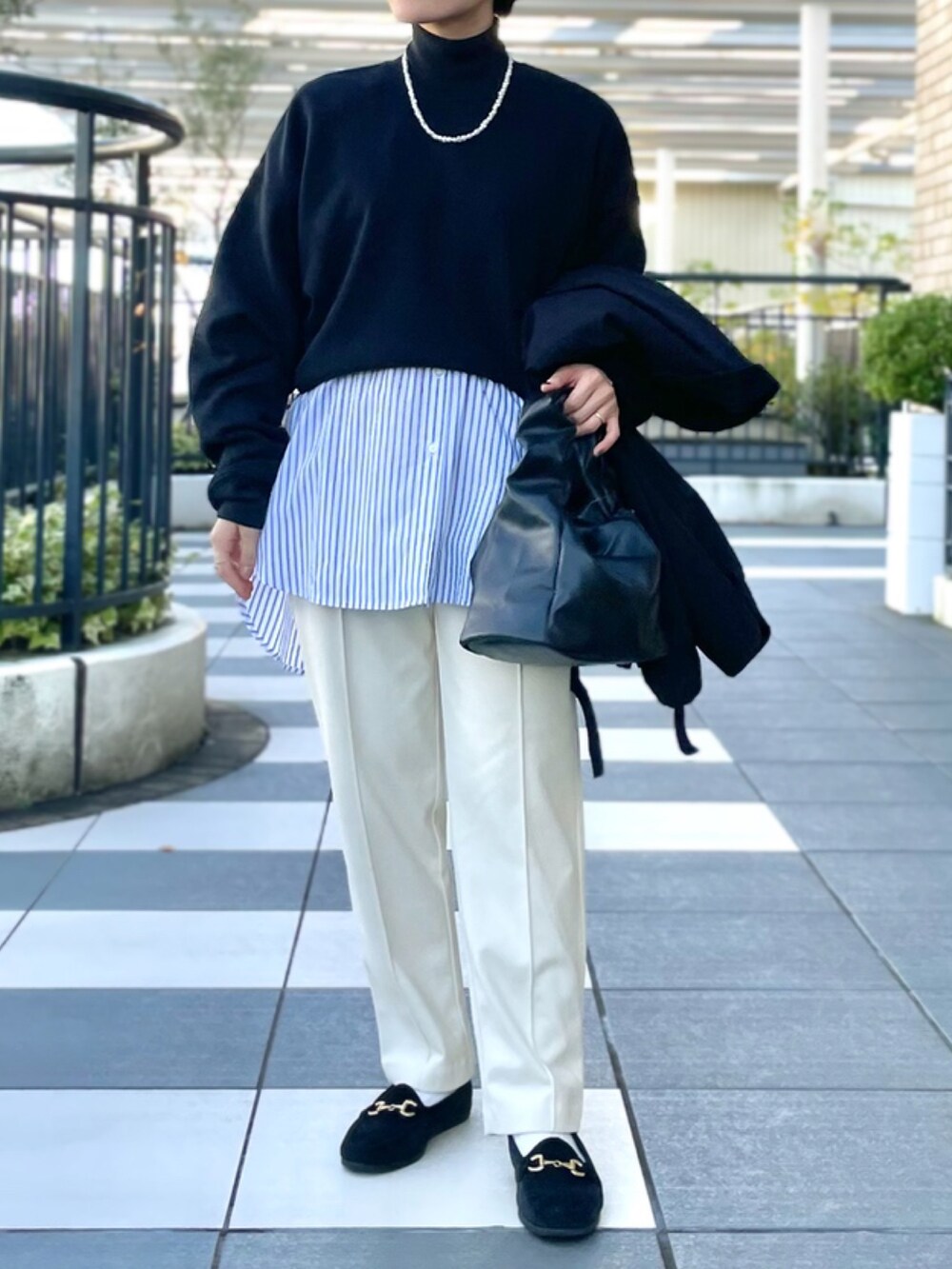 ブラック系のブルゾン、ブラック系のスウェット、ブルー系のシャツ/ブラウスを着用したレディースの秋コーディネートの2枚目の写真