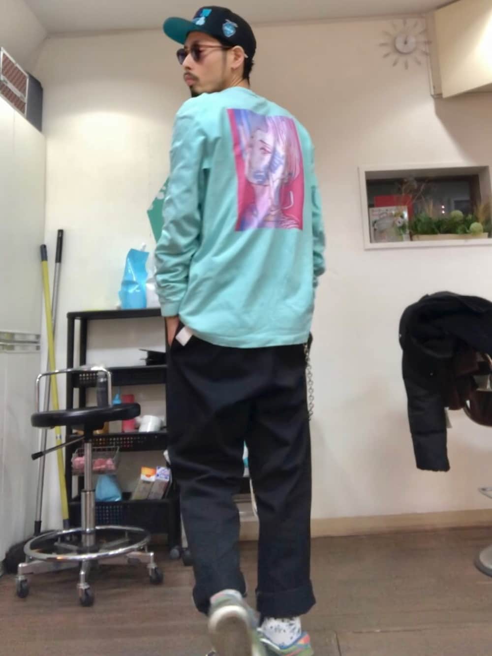 ブラック系のダウンジャケット/コート、ブラック系のパーカー、ブラック系のチノパンツを着用したメンズの冬コーディネートの3枚目の写真