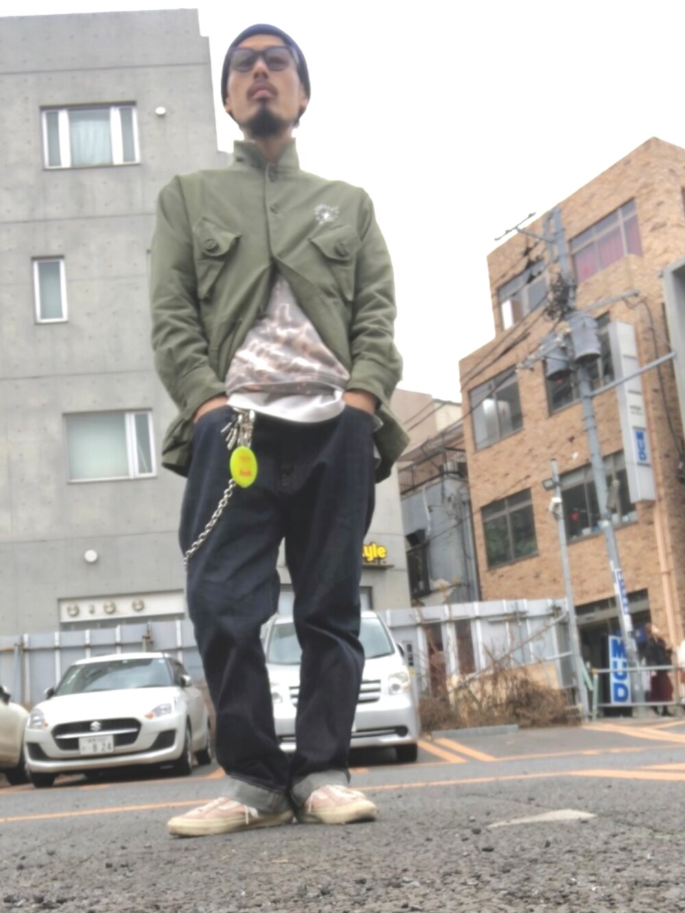 グリーン系のミリタリージャケット、グレー系のスウェット、ブルー系のデニムパンツを着用したメンズの冬コーディネートの2枚目の写真