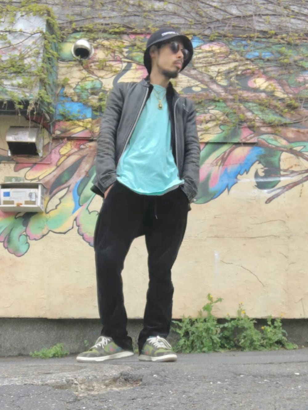 ブラック系のライダースジャケット、ブラック系のその他パンツ、グリーン系のスニーカーを着用したメンズの春コーディネートの2枚目の写真