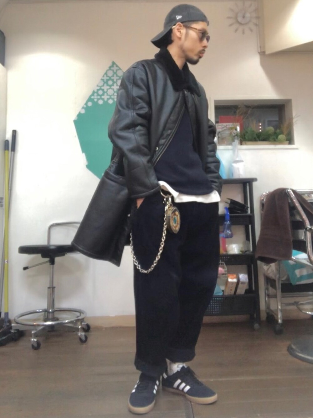 ブラック系のムートンコート、ブルー系のニット/セーター、ブルー系のその他パンツを着用したメンズの冬コーディネートの2枚目の写真