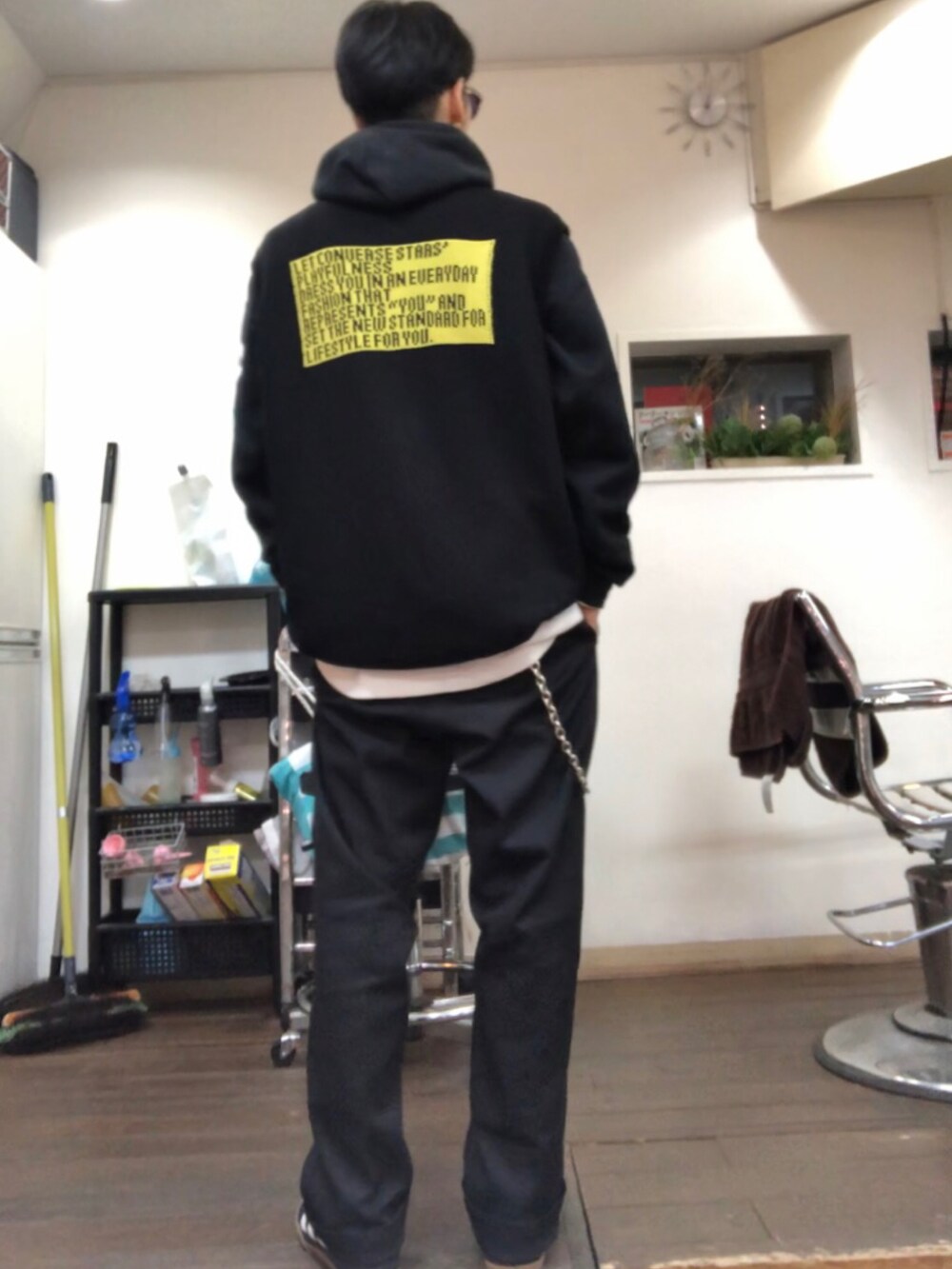 ブラック系のパーカー、ブラック系のベスト、ブラック系のチノパンツを着用したメンズの冬コーディネートの2枚目の写真