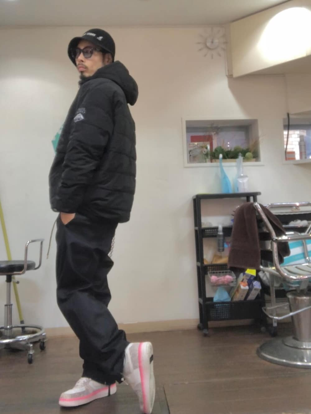 ブラック系のダウンジャケット/コート、ブラック系のチノパンツ、ピンク系のスニーカーを着用したメンズの冬コーディネートの2枚目の写真