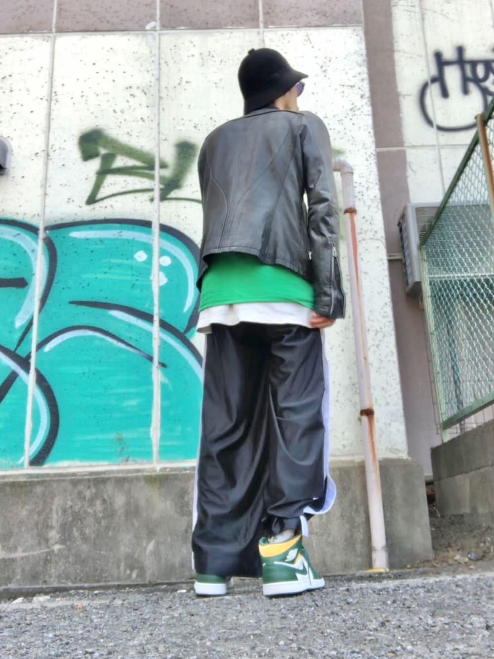 ブラック系のライダースジャケット、グリーン系のTシャツ/カットソー、ブラック系のその他パンツを着用したメンズの春コーディネートの2枚目の写真