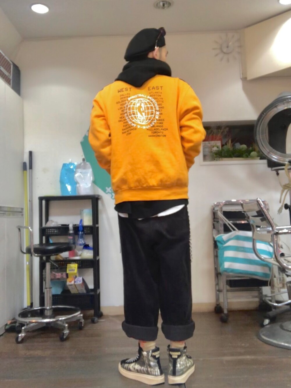 ブラック系のパーカー、オレンジ系のその他アウター、ブラック系のその他パンツを着用したメンズの冬コーディネートの2枚目の写真