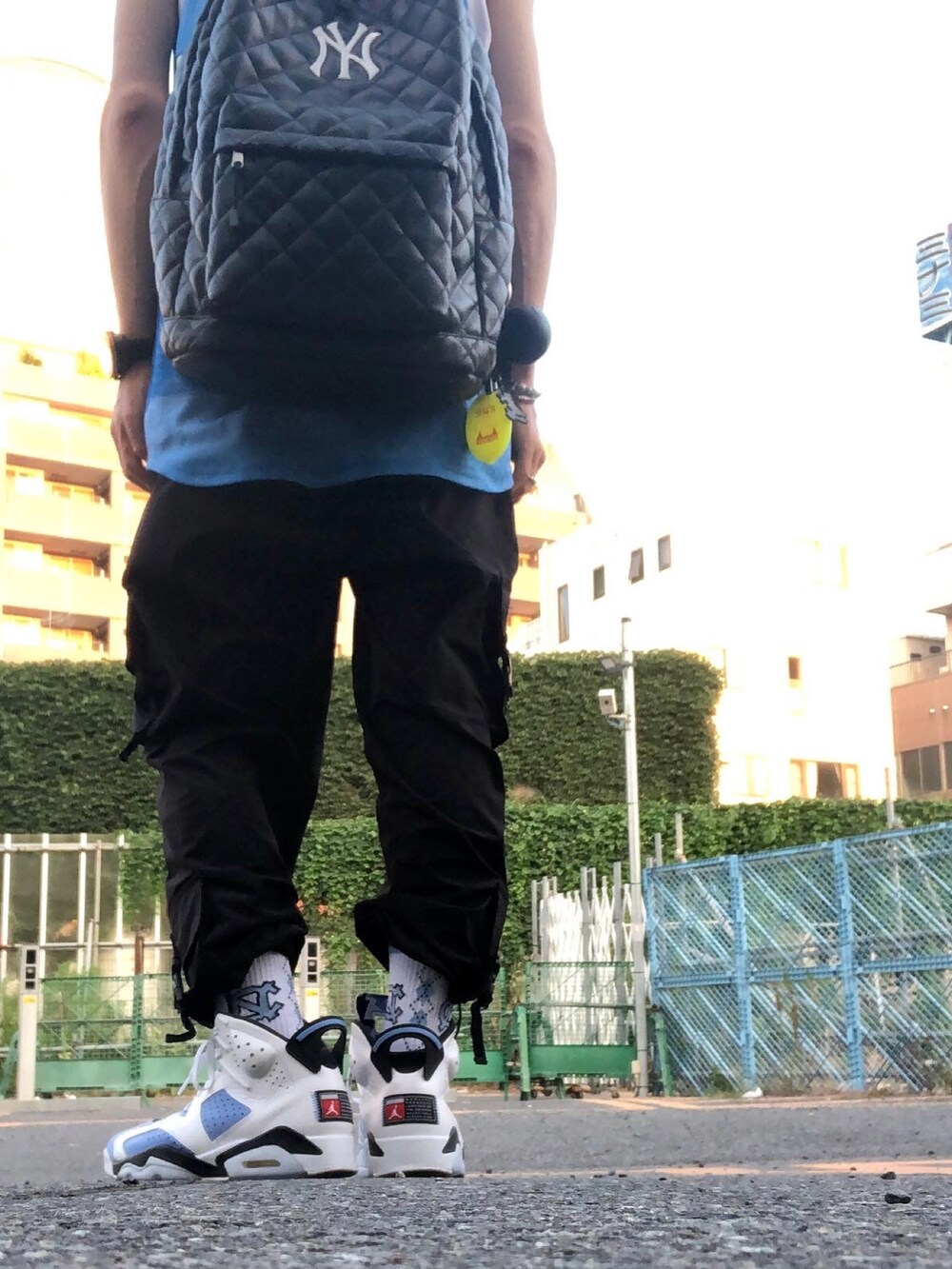 ブラック系のカーゴパンツ、ブルー系のスニーカー、ブラック系のハットを着用したメンズの夏コーディネートの2枚目の写真