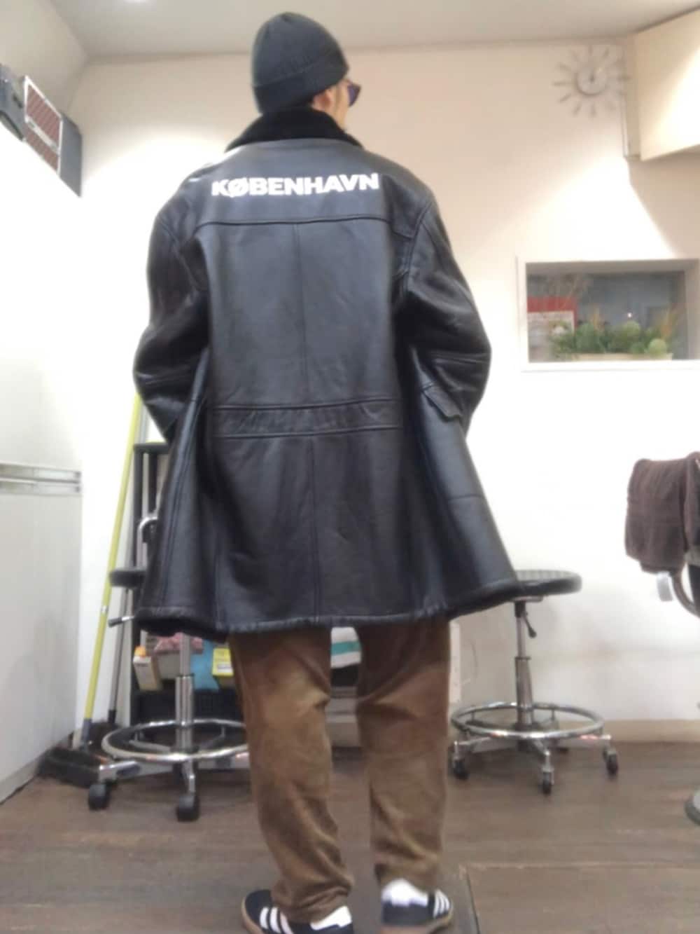 ブラック系のムートンコート、イエロー系のニット/セーター、ホワイト系のTシャツ/カットソーを着用したメンズの冬コーディネートの3枚目の写真