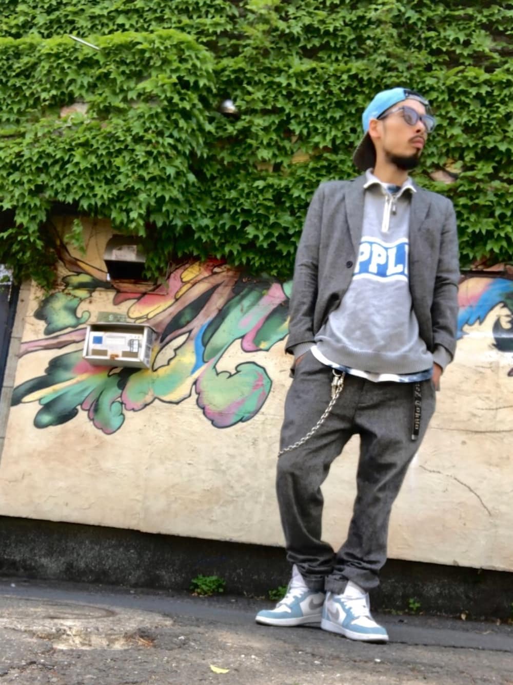 グレー系のニット/セーター、グレー系のテーラードジャケット、グレー系のスラックスを着用したメンズの春コーディネートの2枚目の写真