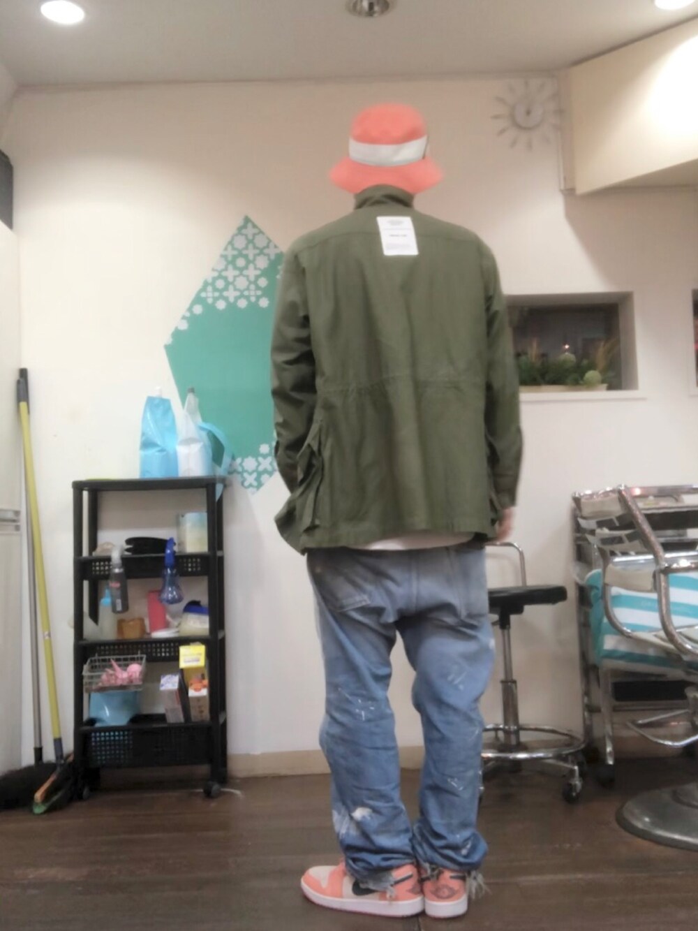 グリーン系のミリタリージャケット、グレー系のスウェット、ブルー系のデニムパンツを着用したメンズの秋コーディネートの2枚目の写真