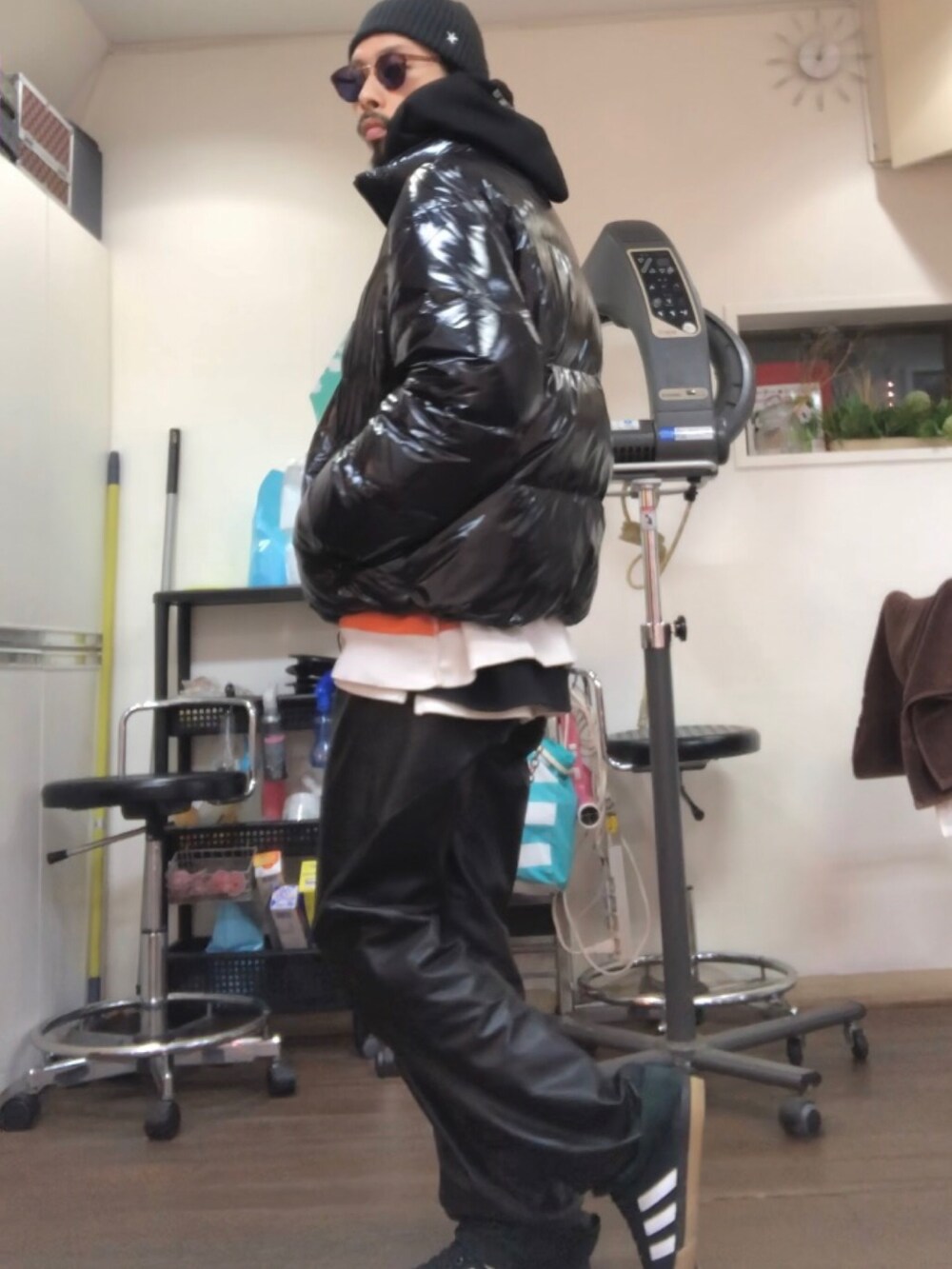 ブラック系のパーカー、ブラック系のダウンジャケット/コート、オレンジ系のニット/セーターを着用したメンズの冬コーディネートの2枚目の写真