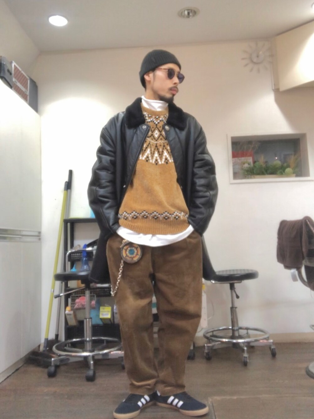 ブラック系のムートンコート、イエロー系のニット/セーター、ホワイト系のTシャツ/カットソーを着用したメンズの冬コーディネートの2枚目の写真