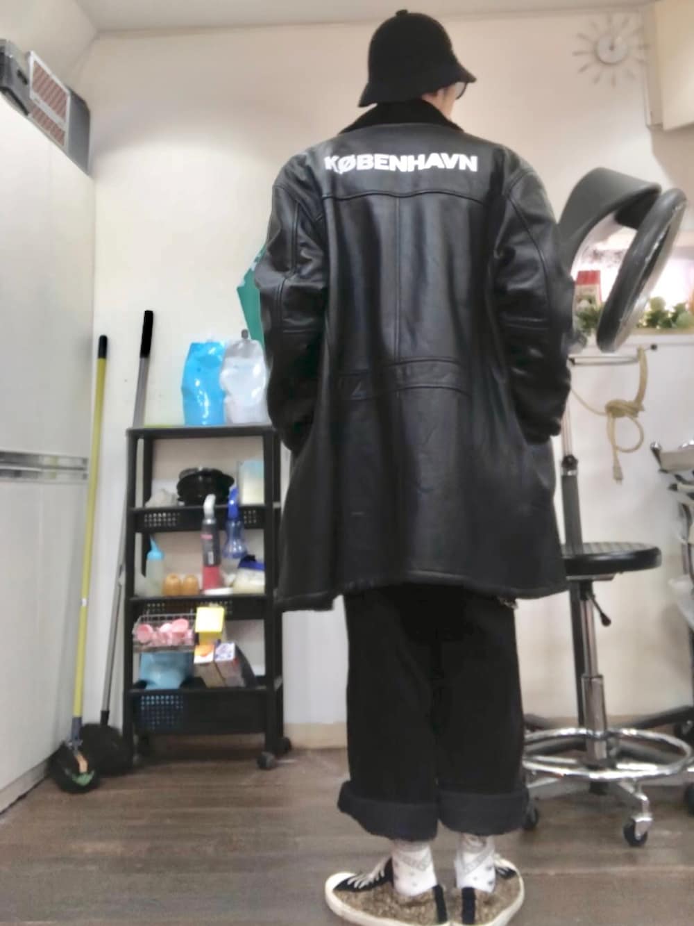 イエロー系のニット/セーター、ブラック系のムートンコート、ブラック系のその他パンツを着用したメンズの冬コーディネートの2枚目の写真