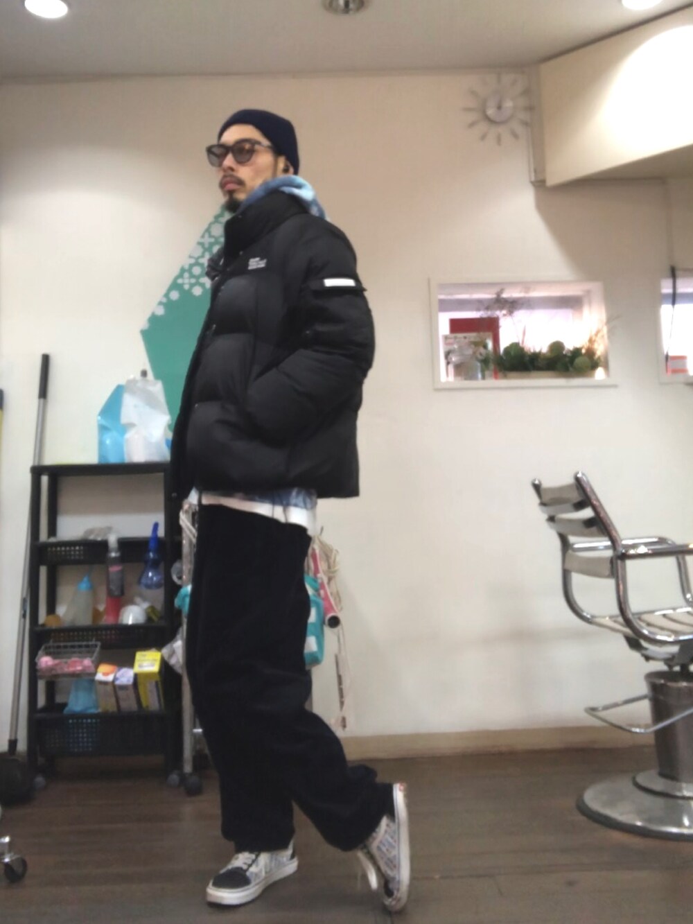 ブルー系のパーカー、ブラック系のダウンジャケット/コート、ブルー系のその他パンツを着用したメンズの冬コーディネートの2枚目の写真