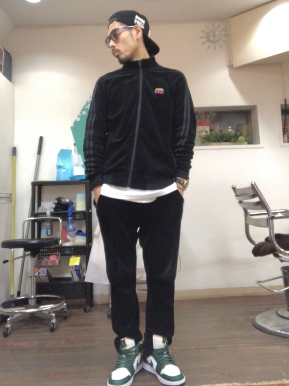 ブラック系のジャージ、ブラック系のその他パンツ、グリーン系のスニーカーを着用したメンズの冬コーディネートの2枚目の写真