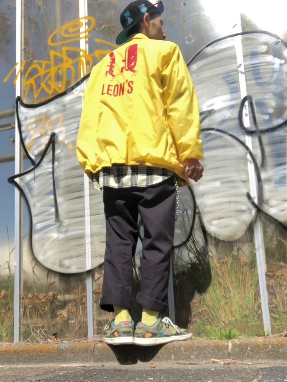 イエロー系のナイロンジャケット、イエロー系のシャツ/ブラウス、グリーン系のTシャツ/カットソーを着用したメンズの春コーディネートの2枚目の写真