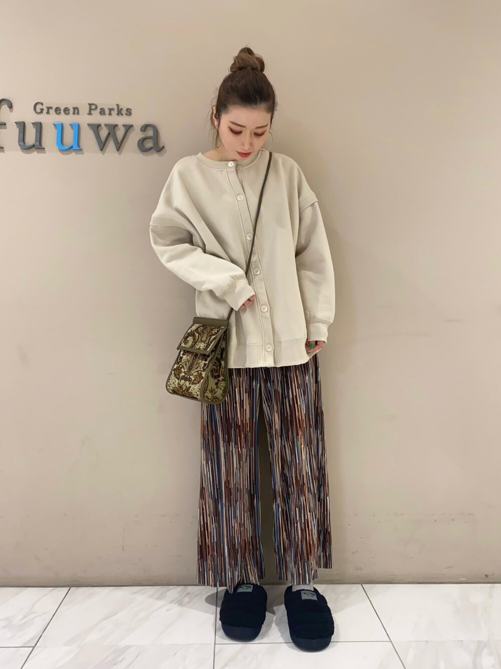 ホワイト系のカーディガン/ボレロ、ブラウン系のその他パンツ、ブラック系のシューズを着用したレディースの秋コーディネートの2枚目の写真