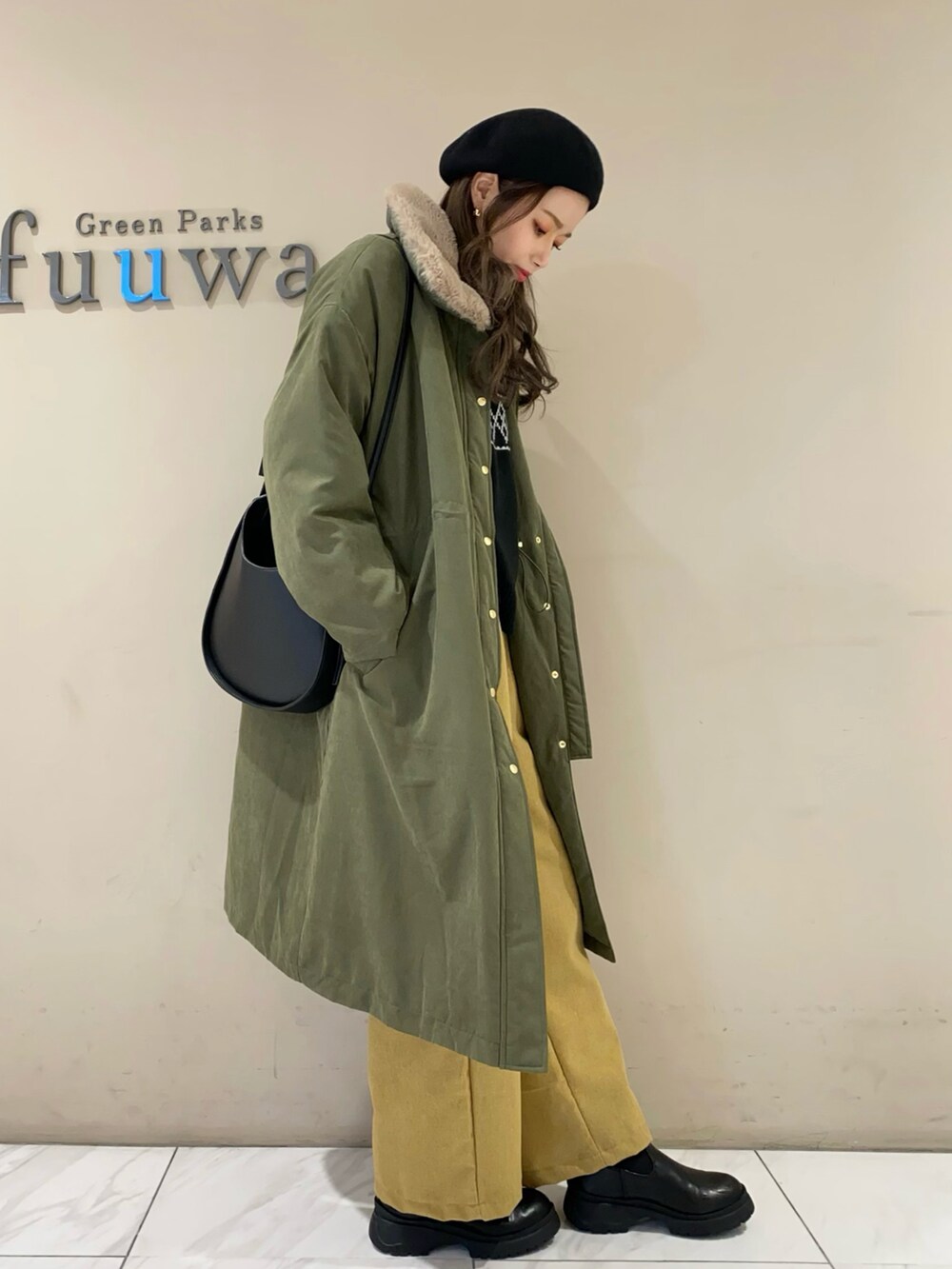 ブラック系のニット/セーター、グリーン系のジャケット/アウター、イエロー系のその他パンツを着用したレディースの冬コーディネートの2枚目の写真