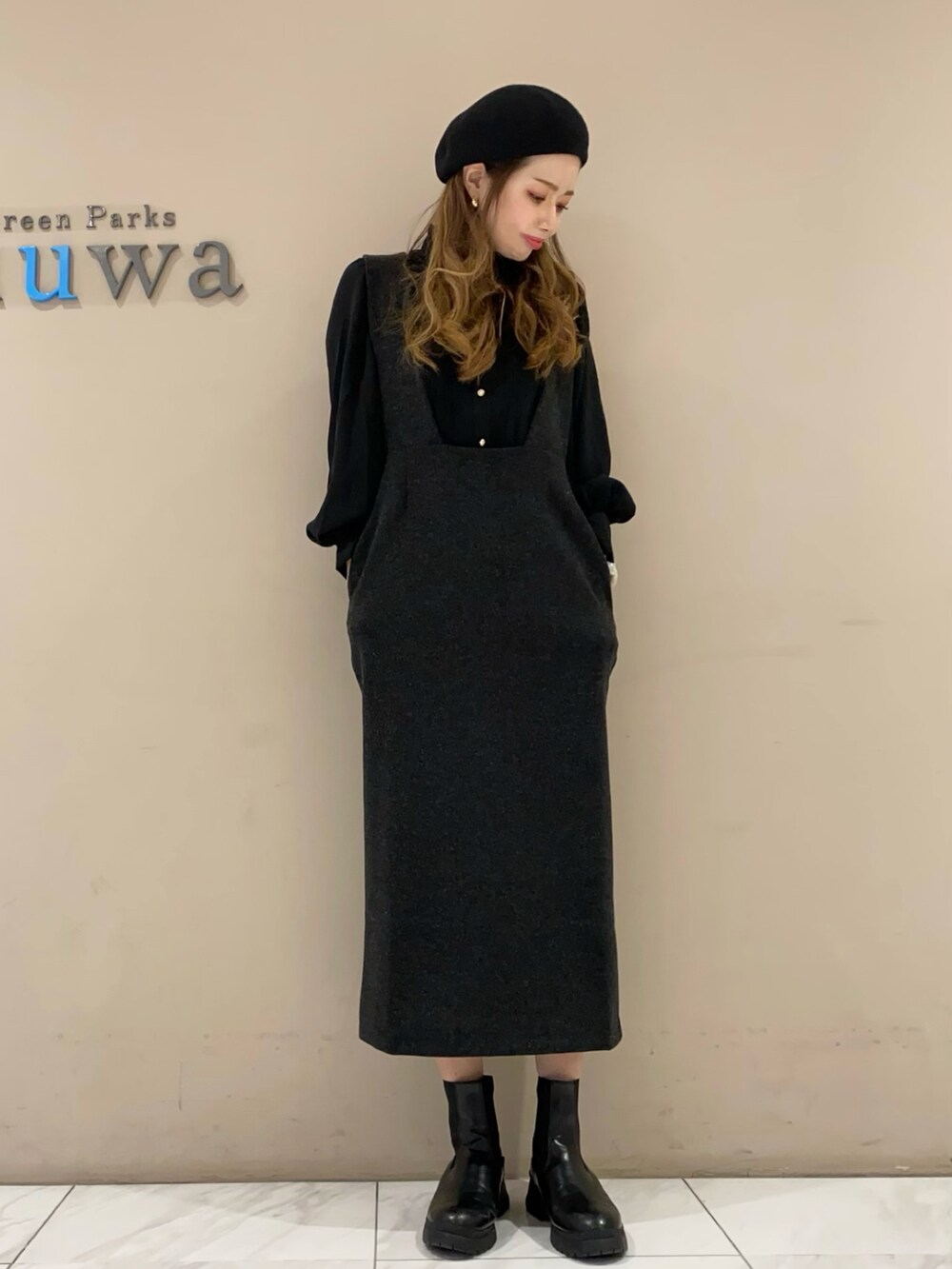 グレー系のワンピース、ブラック系のブーツ、ブラック系のシャツ/ブラウスを着用したレディースの冬コーディネートの2枚目の写真