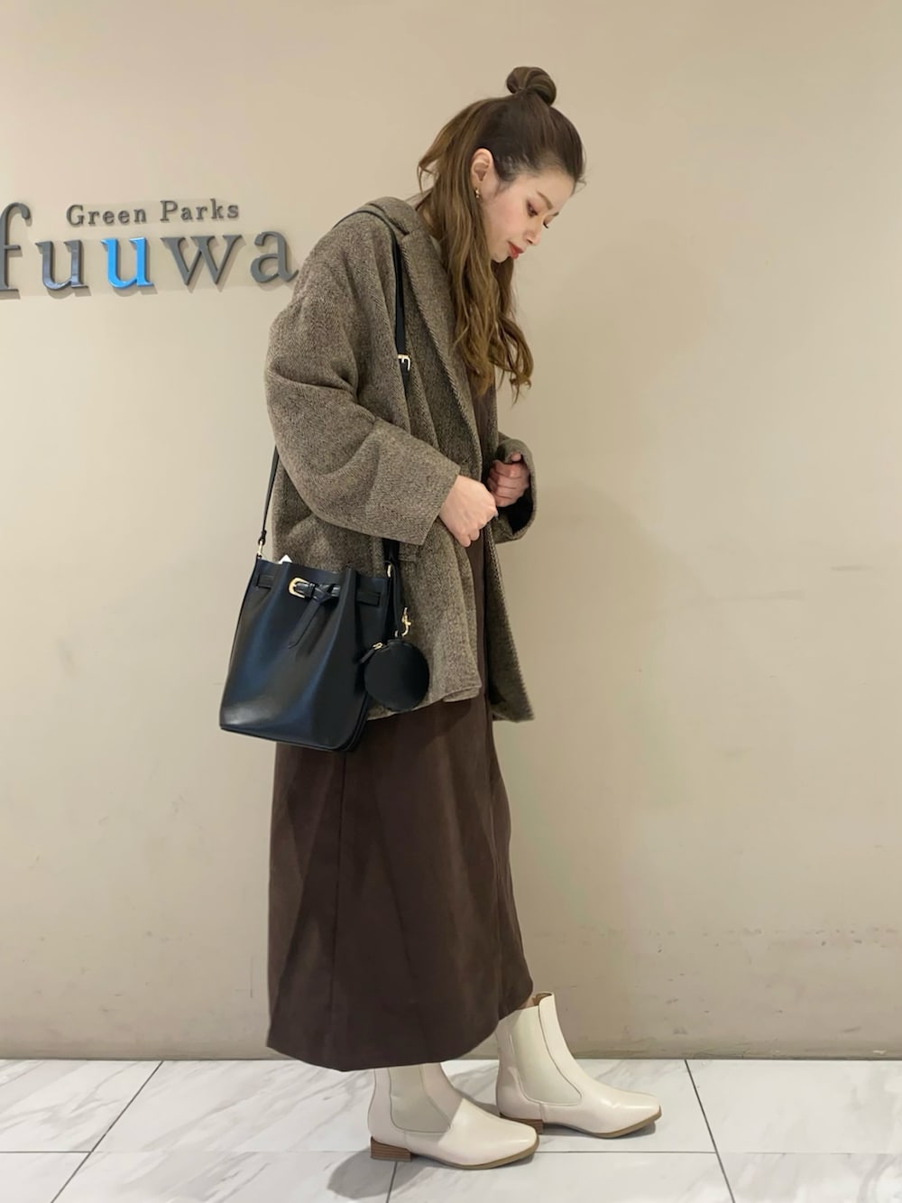 ブラウン系のジャンパースカート、ブラック系のブーツ、ブラック系のショルダーバッグを着用したレディースの冬コーディネートの2枚目の写真