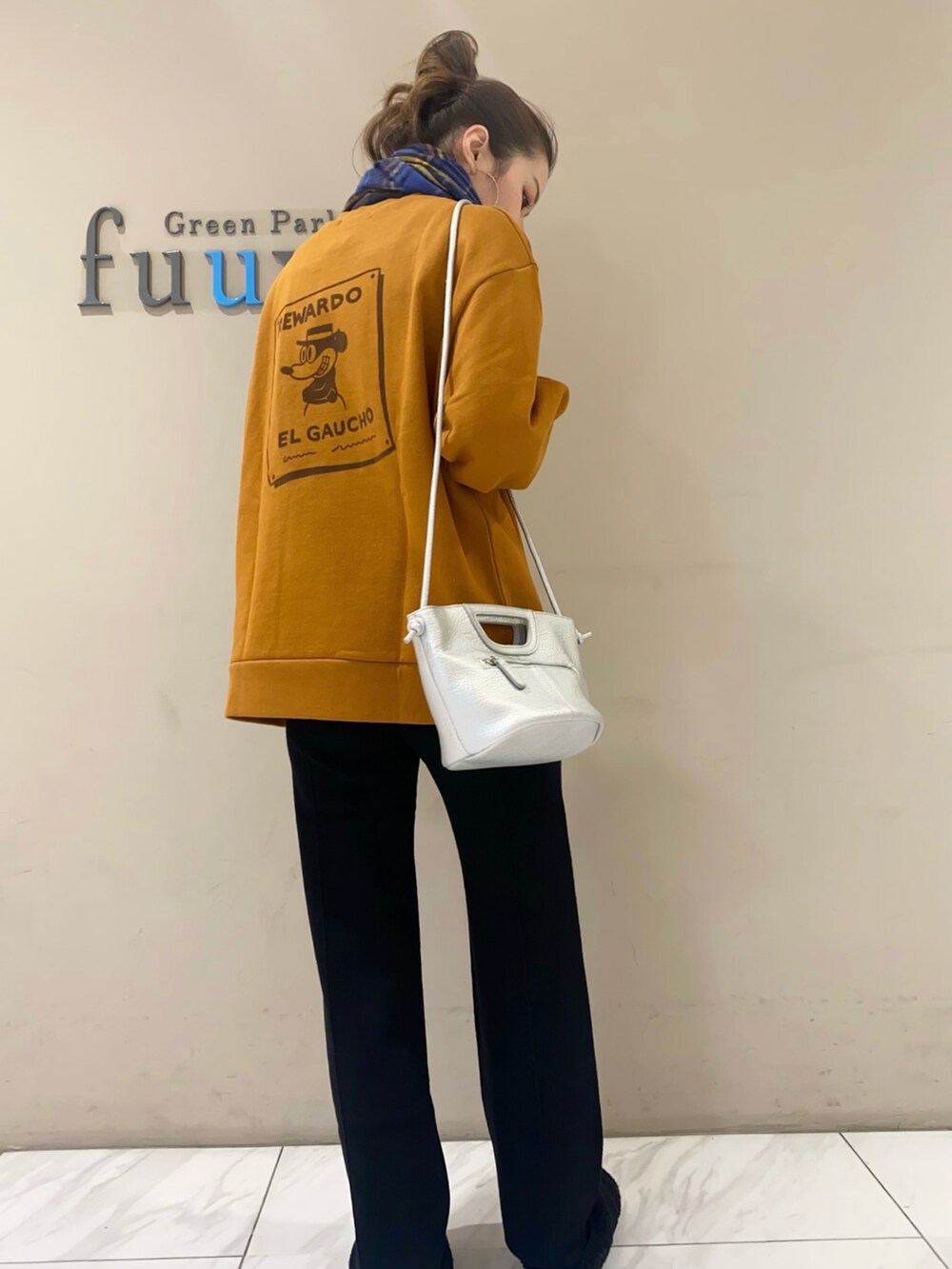 シルバー系のショルダーバッグ、ブラウン系のトップス、ブラウン系のパンツを着用したレディースの秋コーディネートの2枚目の写真