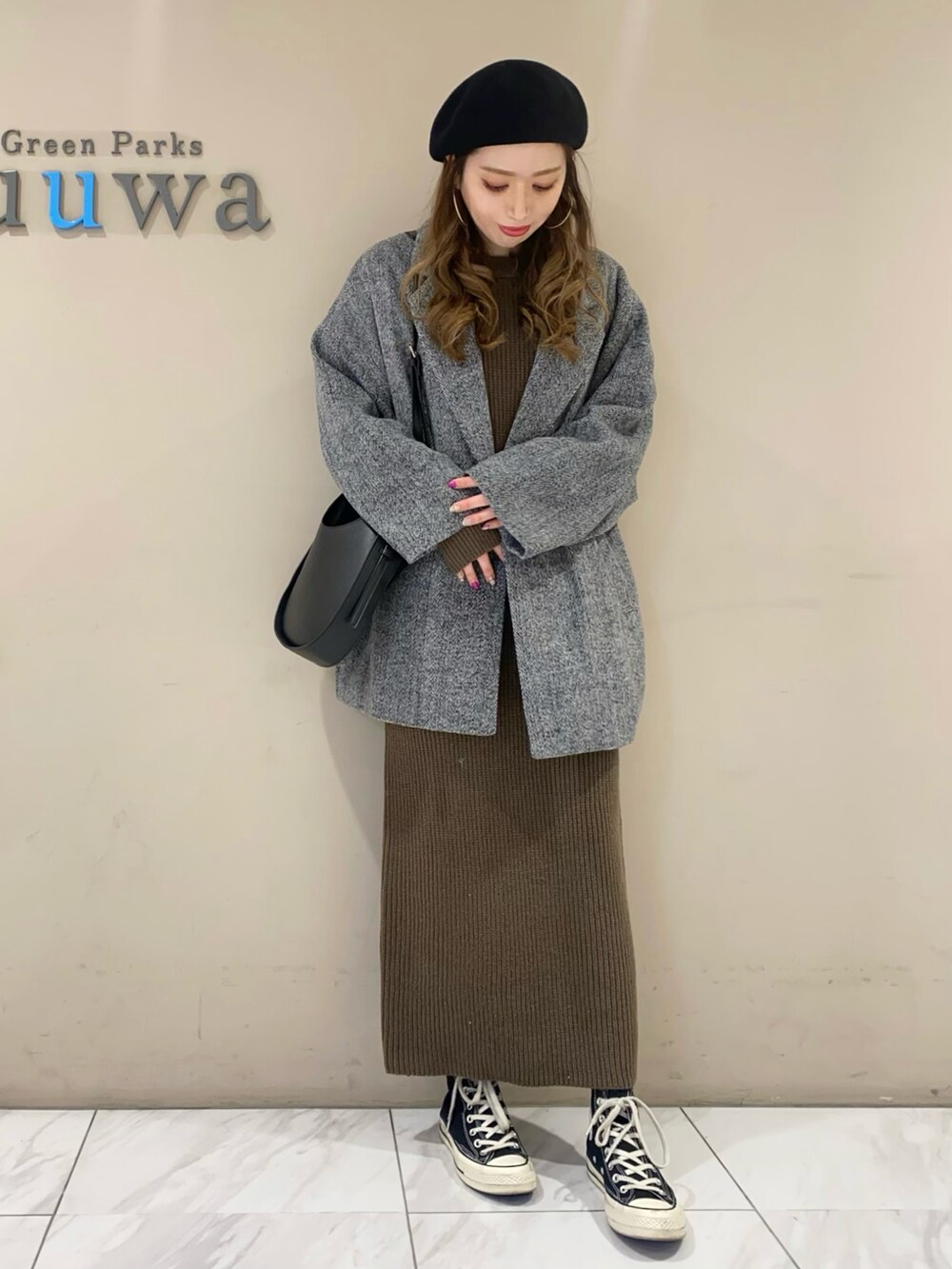 ブラック系のテーラードジャケット、ブラック系のショルダーバッグ、グリーン系のワンピースを着用したレディースの秋コーディネートの2枚目の写真