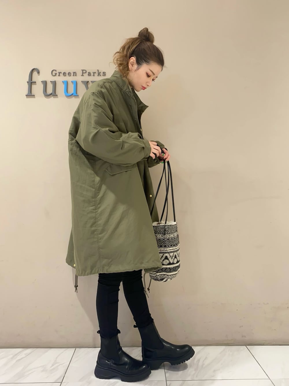 パープル系のニット/セーター、グリーン系のジャケット/アウター、ブルー系のデニムパンツを着用したレディースの冬コーディネートの2枚目の写真