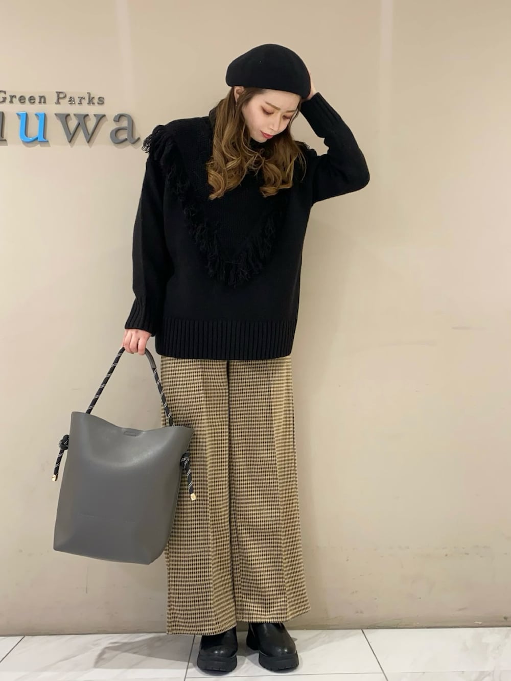 ブラック系のニット/セーター、グレー系のトートバッグ、ホワイト系のその他パンツを着用したレディースの冬コーディネートの2枚目の写真