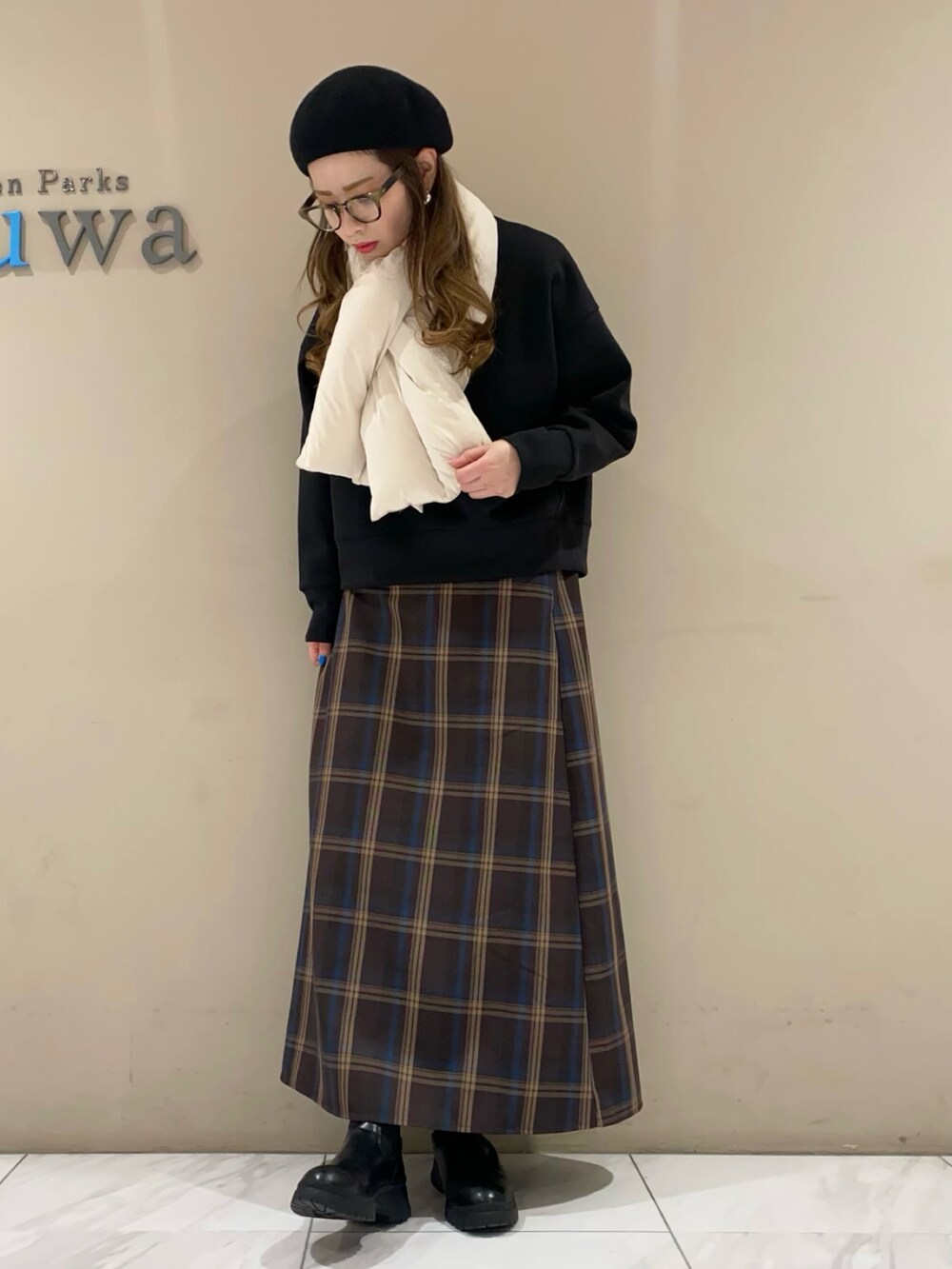 ブラック系のスウェット、ブラウン系のスカート、ブラック系のブーツを着用したレディースの冬コーディネートの2枚目の写真