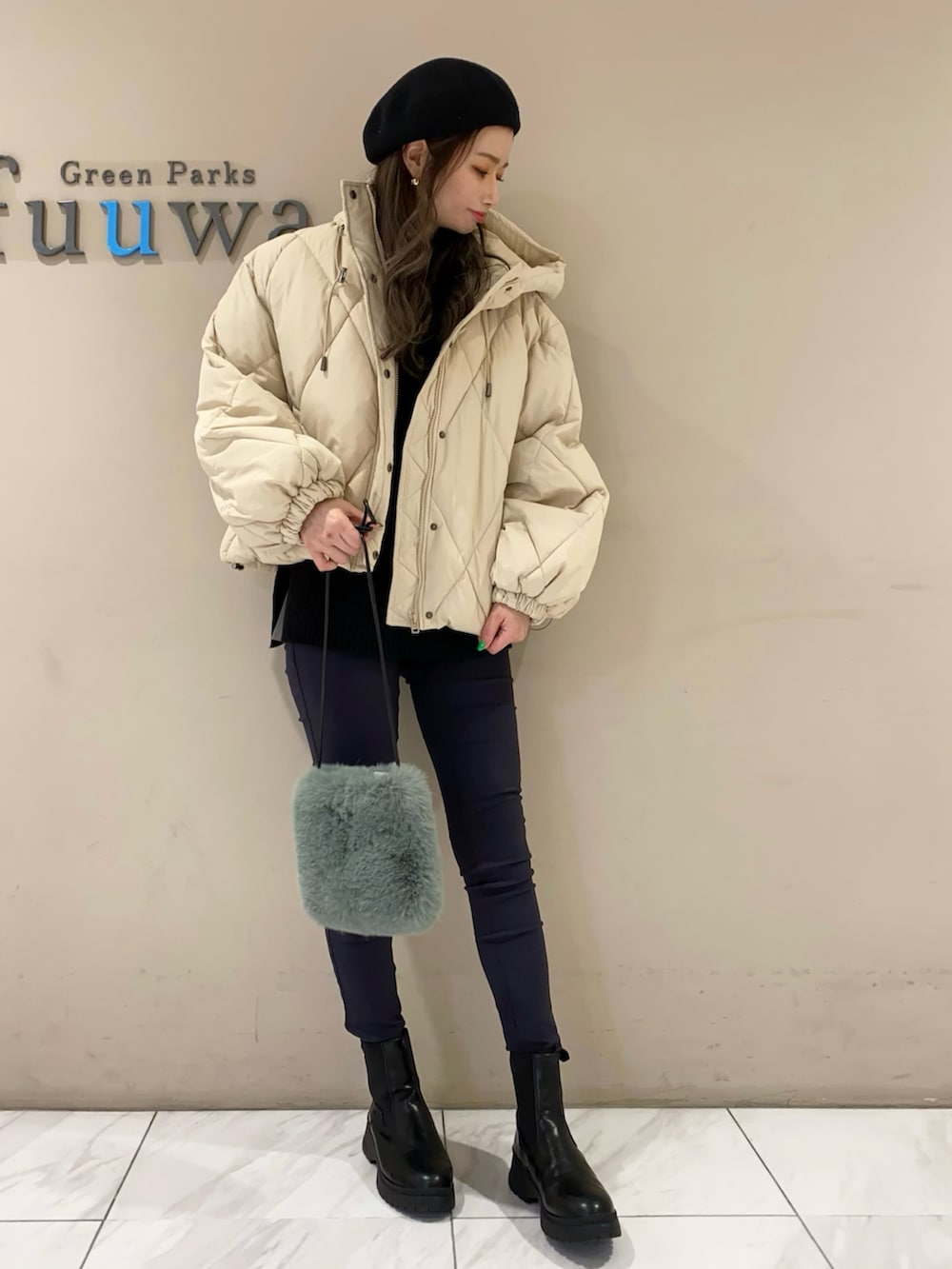 ブラック系のブーツ、ブラック系のパンツ、グリーン系のショルダーバッグを着用したレディースの冬コーディネートの2枚目の写真