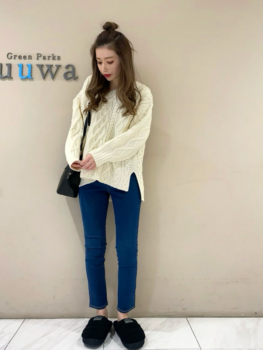 ホワイト系のニット/セーター、ブラック系のショルダーバッグ、ブルー系のデニムパンツを着用したレディースの秋コーディネートの2枚目の写真