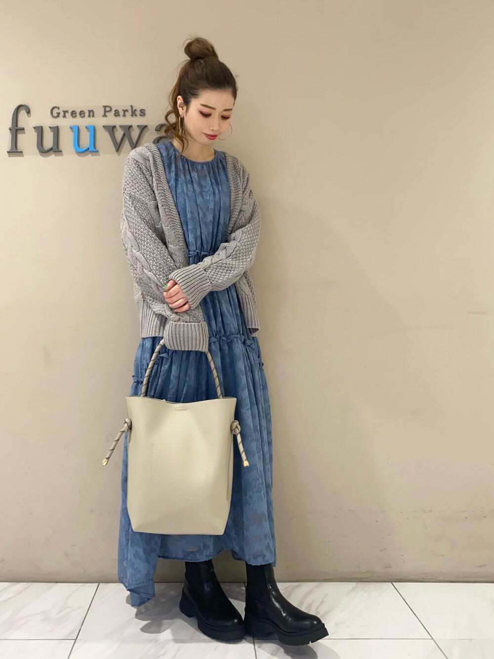 ブルー系のワンピース、ブラック系のブーツ、グレー系のトートバッグを着用したレディースの秋コーディネートの3枚目の写真