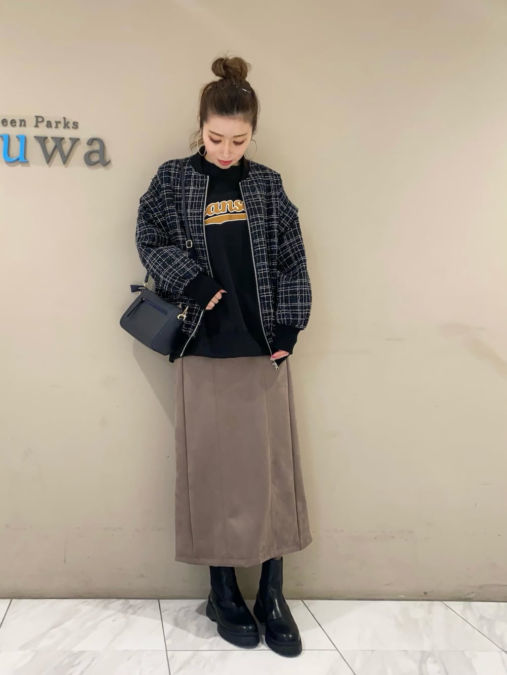 ブルー系のブルゾン、ブラック系のスウェット、ブラウン系のスカートを着用したレディースの秋コーディネートの2枚目の写真