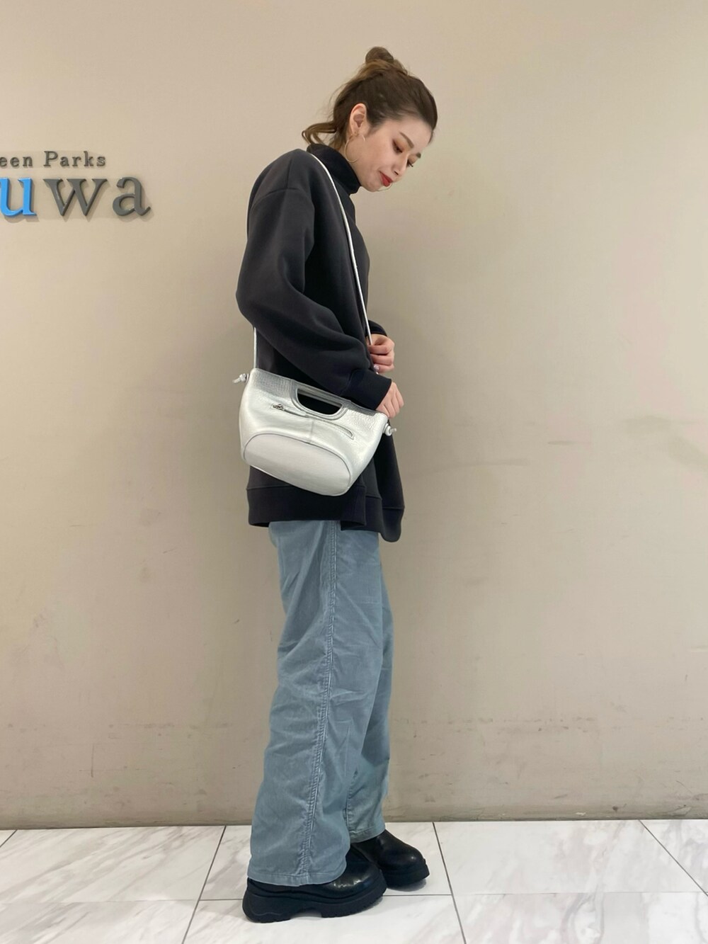 グレー系のスウェット、ブルー系のその他パンツ、シルバー系のショルダーバッグを着用したレディースの冬コーディネートの2枚目の写真