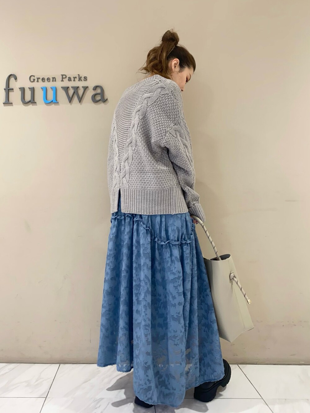 ブルー系のワンピース、ブラック系のブーツ、グレー系のトートバッグを着用したレディースの秋コーディネートの4枚目の写真