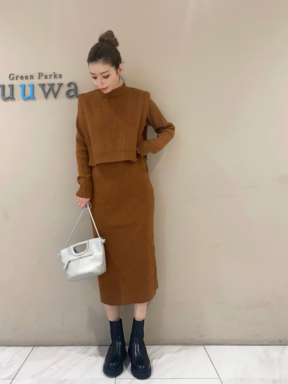 ブラック系のブーツ、シルバー系のショルダーバッグ、イエロー系のワンピースを着用したレディースの秋コーディネートの2枚目の写真