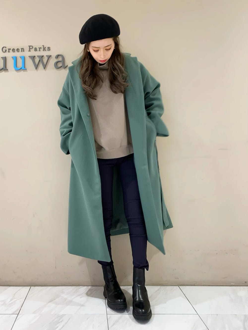 ブラック系のパンツ、ブラック系のブーツ、ベージュ系のスウェットを着用したレディースの冬コーディネートの2枚目の写真