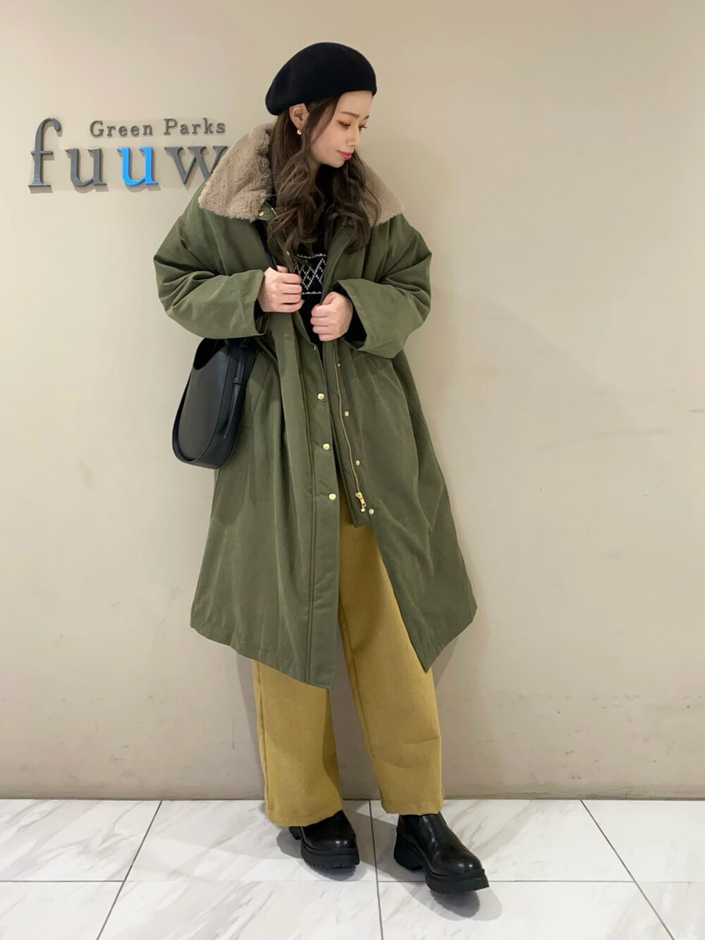 ブラック系のニット/セーター、グリーン系のジャケット/アウター、イエロー系のその他パンツを着用したレディースの冬コーディネートの3枚目の写真