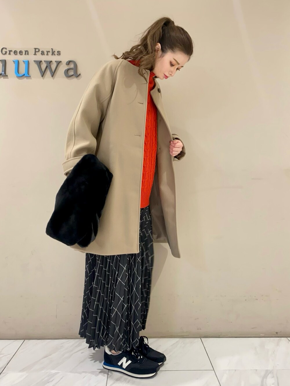 レッド系のニット/セーター、ベージュ系のその他アウター、グレー系のスカートを着用したレディースの冬コーディネートの2枚目の写真