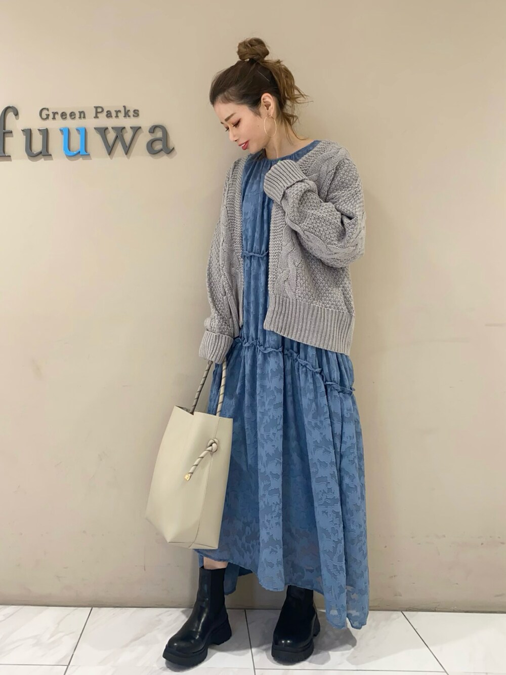 ブルー系のワンピース、ブラック系のブーツ、グレー系のトートバッグを着用したレディースの秋コーディネートの2枚目の写真