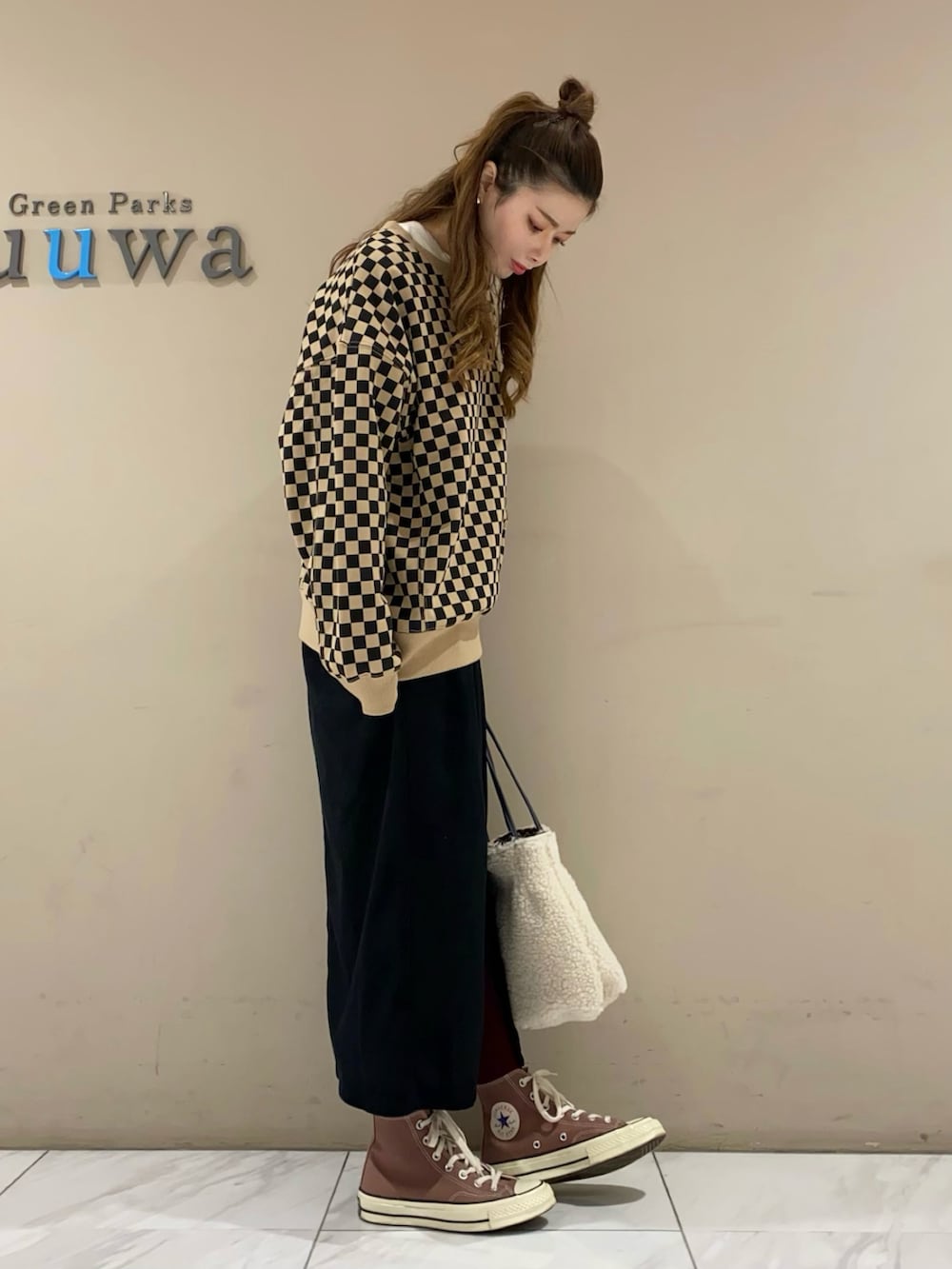 ベージュ系のスウェット、ブラック系のスカートを着用したレディースの冬コーディネートの2枚目の写真