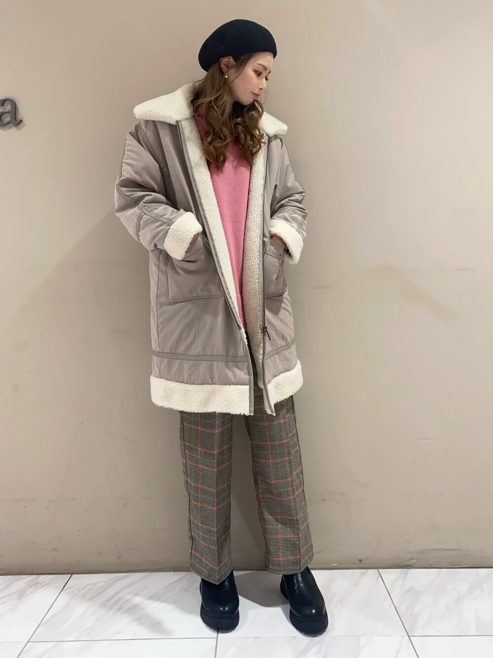 ピンク系のニット/セーター、ブラック系のその他パンツ、ブラック系のブーツを着用したレディースの冬コーディネートの2枚目の写真