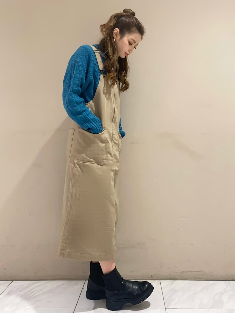 ホワイト系のその他アウター、ベージュ系のジャンパースカート、ブラック系のブーツを着用したレディースの冬コーディネートの3枚目の写真