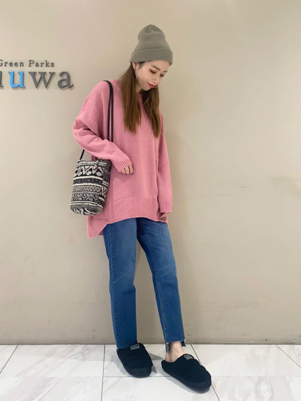 ピンク系のニット/セーター、ブルー系のデニムパンツ、ブラック系のシューズを着用したレディースの秋コーディネートの2枚目の写真