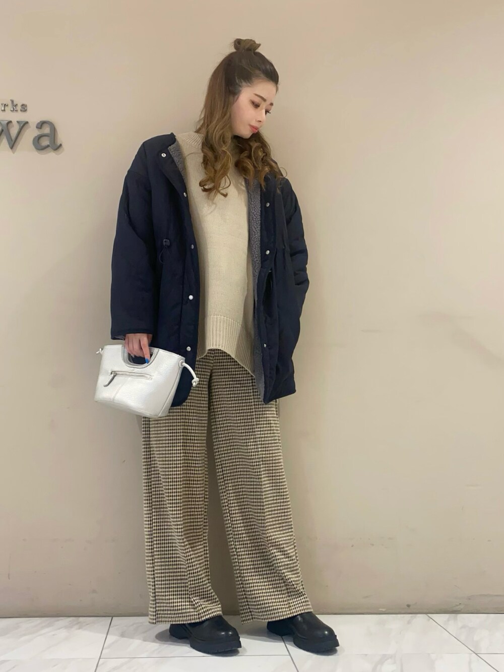 シルバー系のショルダーバッグ、ブルー系のその他アウター、ベージュ系のニット/セーターを着用したレディースの冬コーディネートの2枚目の写真