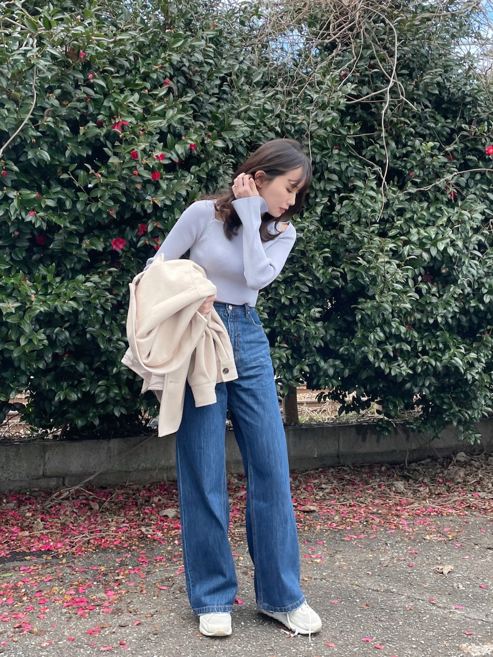 ブルー系のデニムパンツ、ホワイト系のスニーカー、パープル系のニット/セーターを着用したレディースの冬コーディネートの2枚目の写真