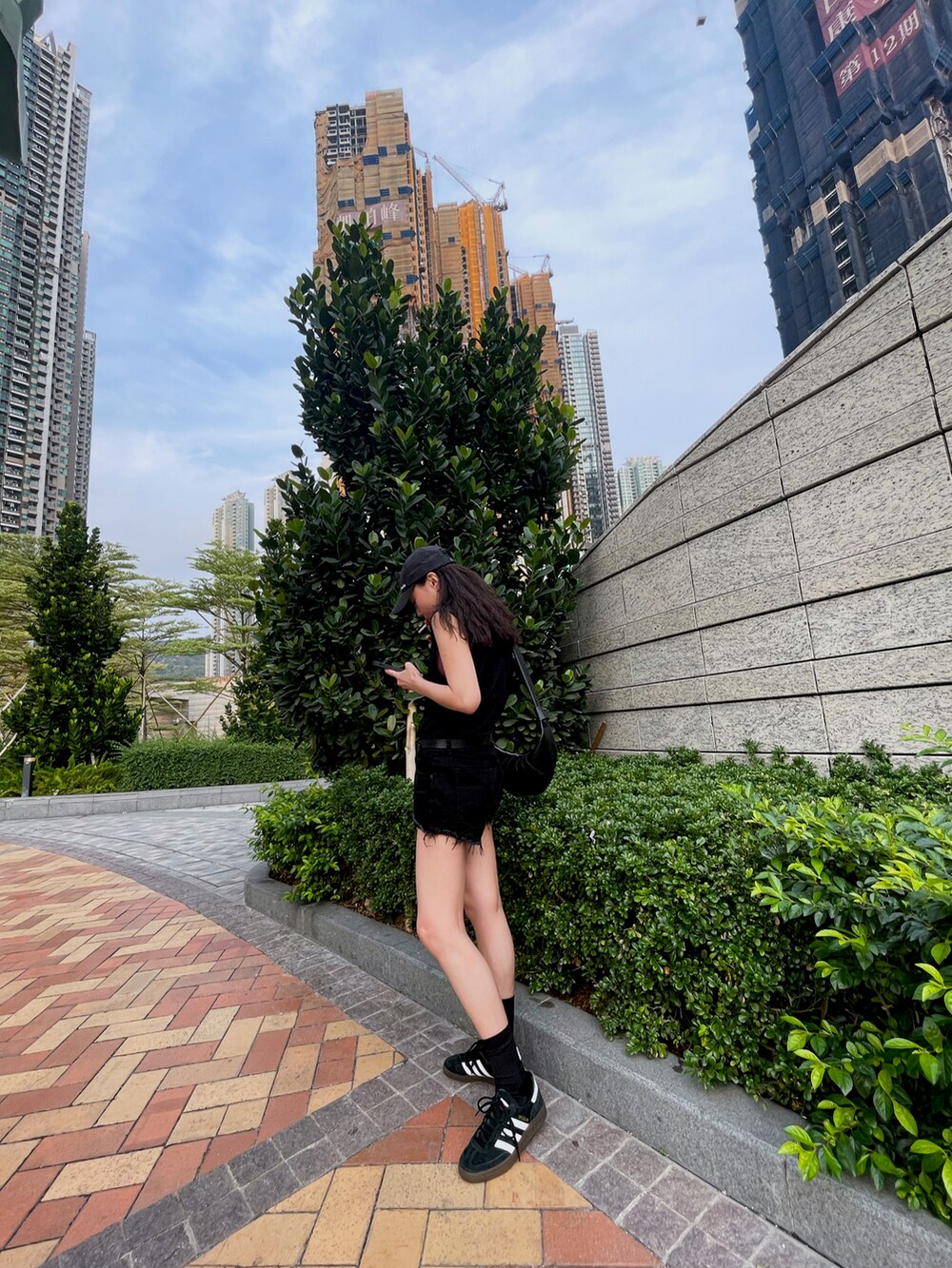 ブラック系のスニーカーを着用したレディースの春コーディネートの2枚目の写真