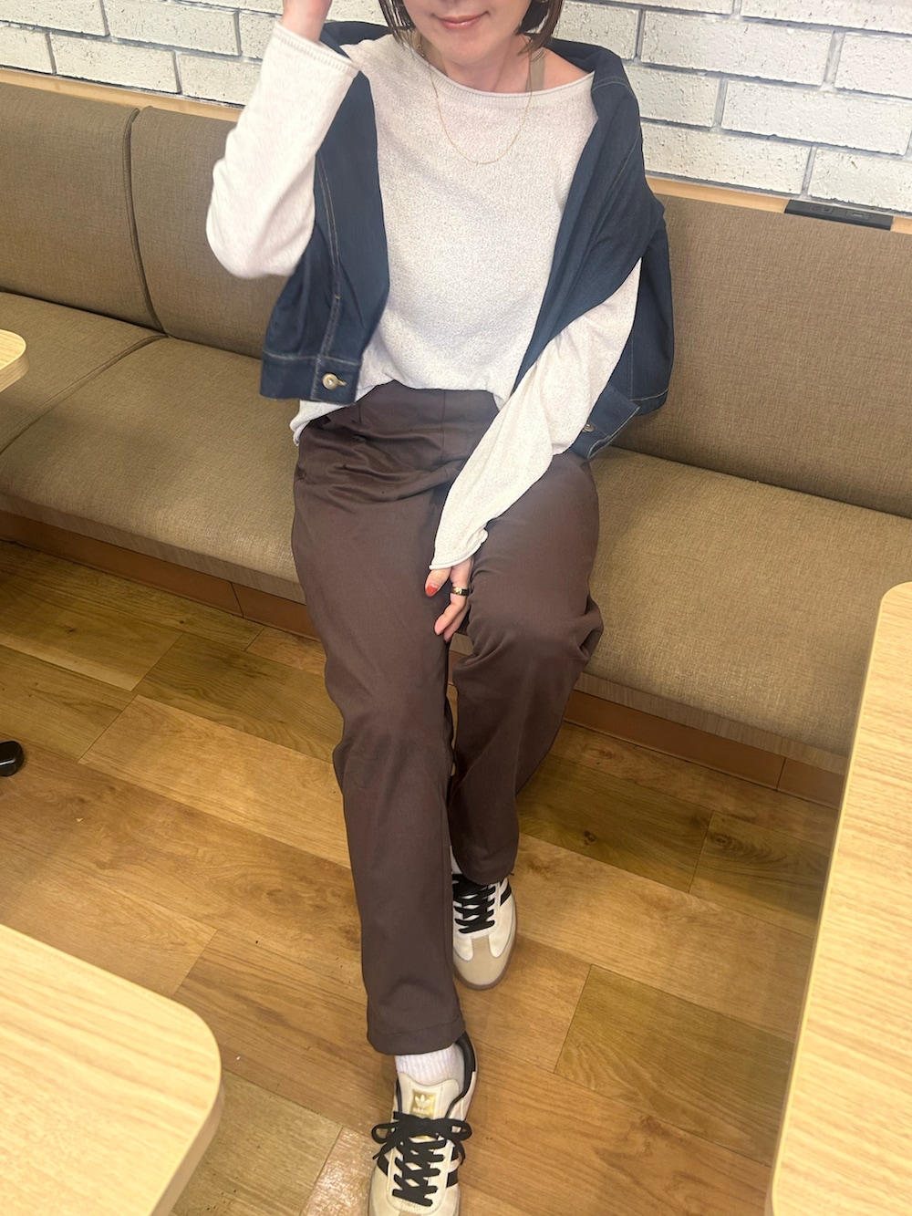 ブルー系のデニムジャケット、ブラウン系のその他パンツ、ベージュ系のスニーカーを着用したレディースの秋コーディネートの2枚目の写真