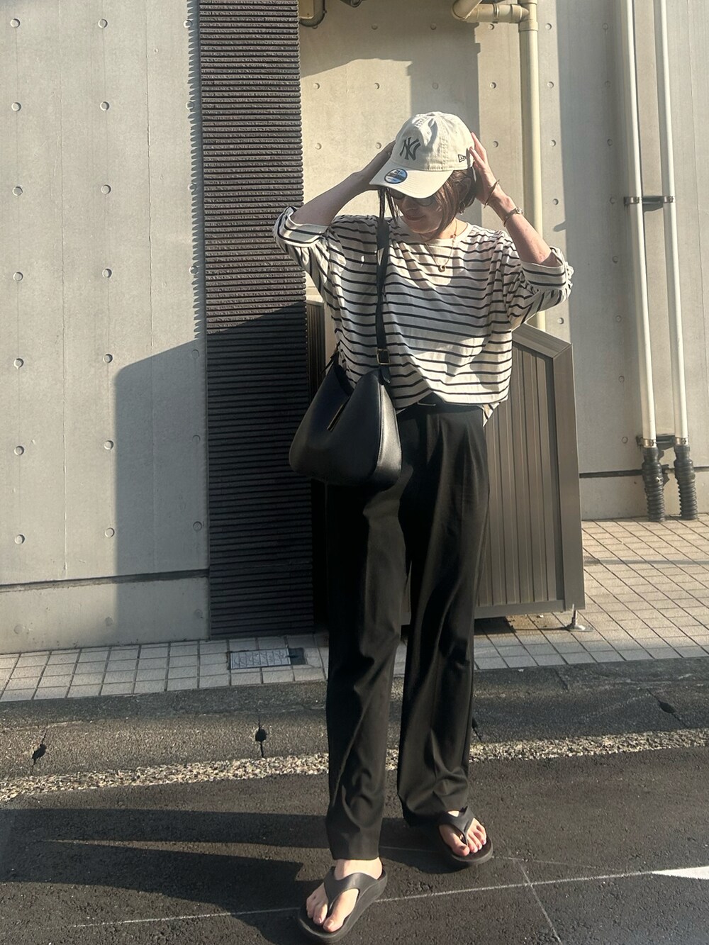 ブラック系のサンダル、その他のTシャツ/カットソー、ブラック系のショルダーバッグを着用したレディースの夏コーディネートの3枚目の写真