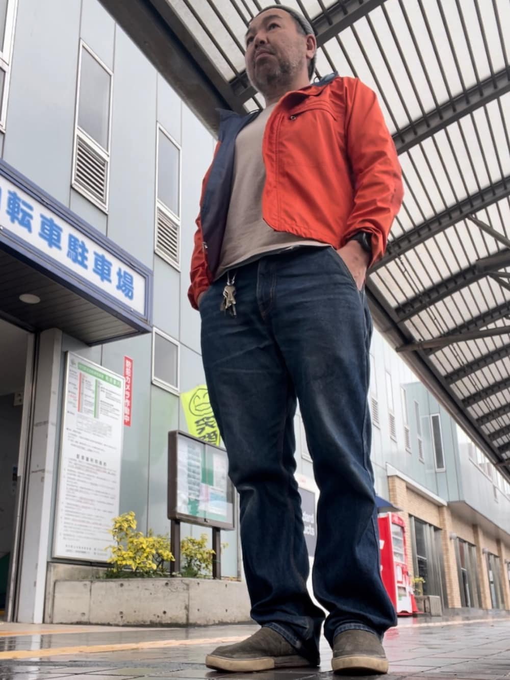 オレンジ系のマウンテンパーカー、ブルー系のデニムパンツ、ベージュ系のその他シューズを着用したメンズの春コーディネートの2枚目の写真